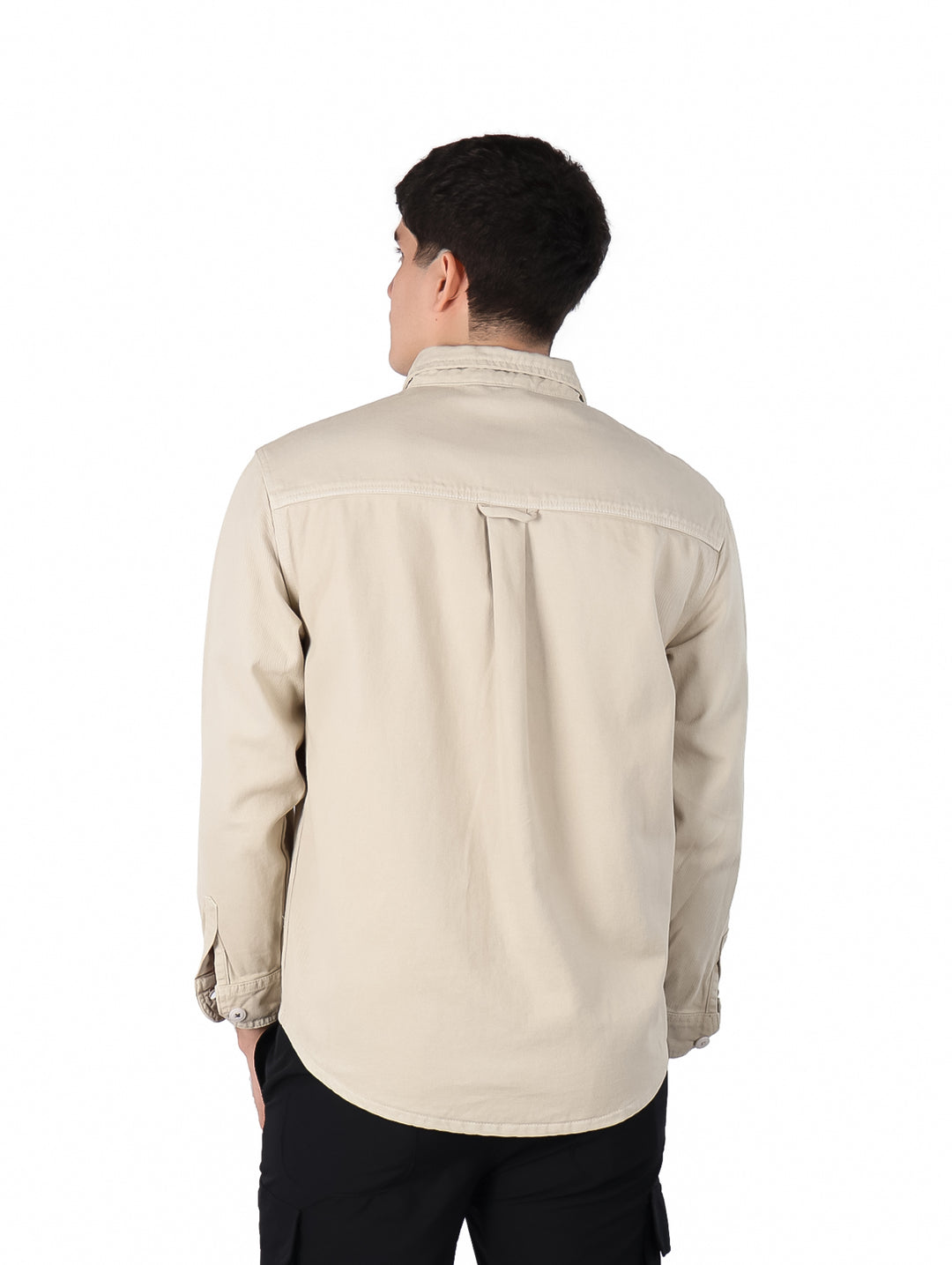 Hombre vistiendo una camisa de manga larga color beige con botones y bolsillo frontal.