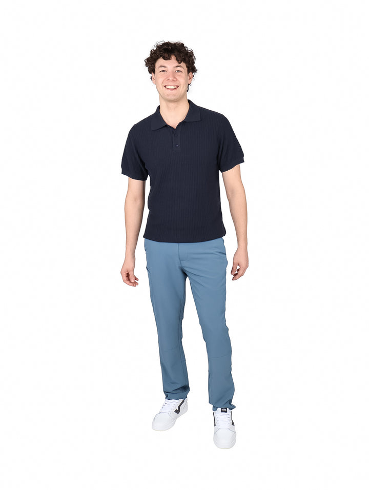 Hombre vistiendo una playera polo de color azul marino con cuello y botones.