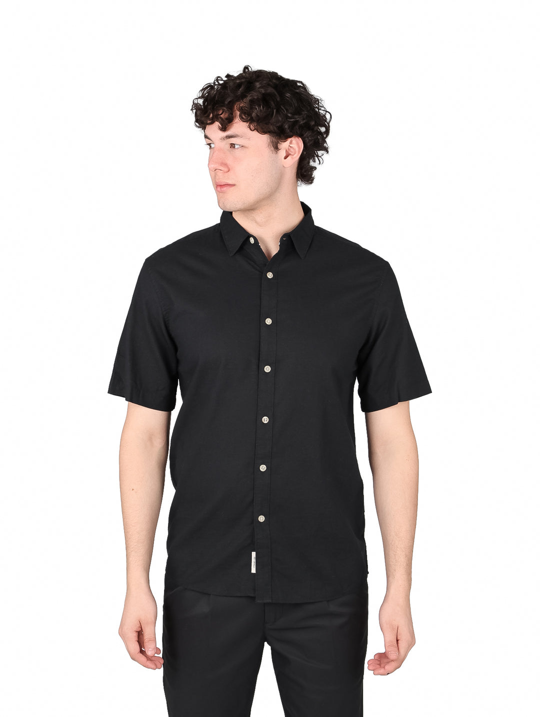 Hombre vistiendo una camisa negra de manga corta con botones y cuello.