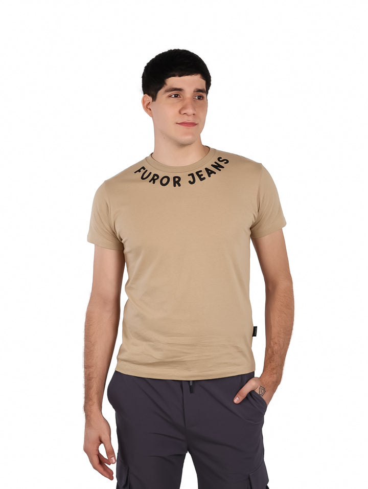 Hombre vistiendo una playera color beige con cuello redondo y texto &