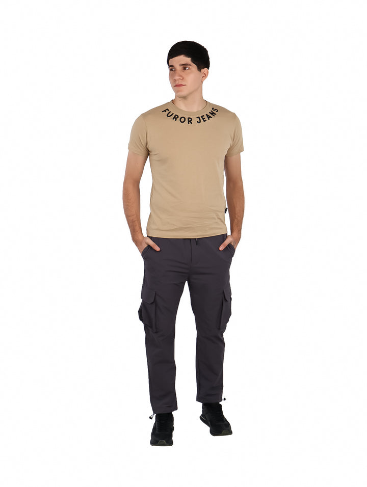 Hombre vistiendo una playera color beige con cuello redondo y texto &