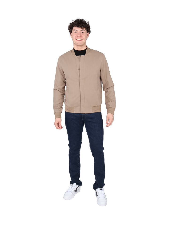 Hombre usando una chamarra bomber DKNY color taupe de estilo casual y textura mate.