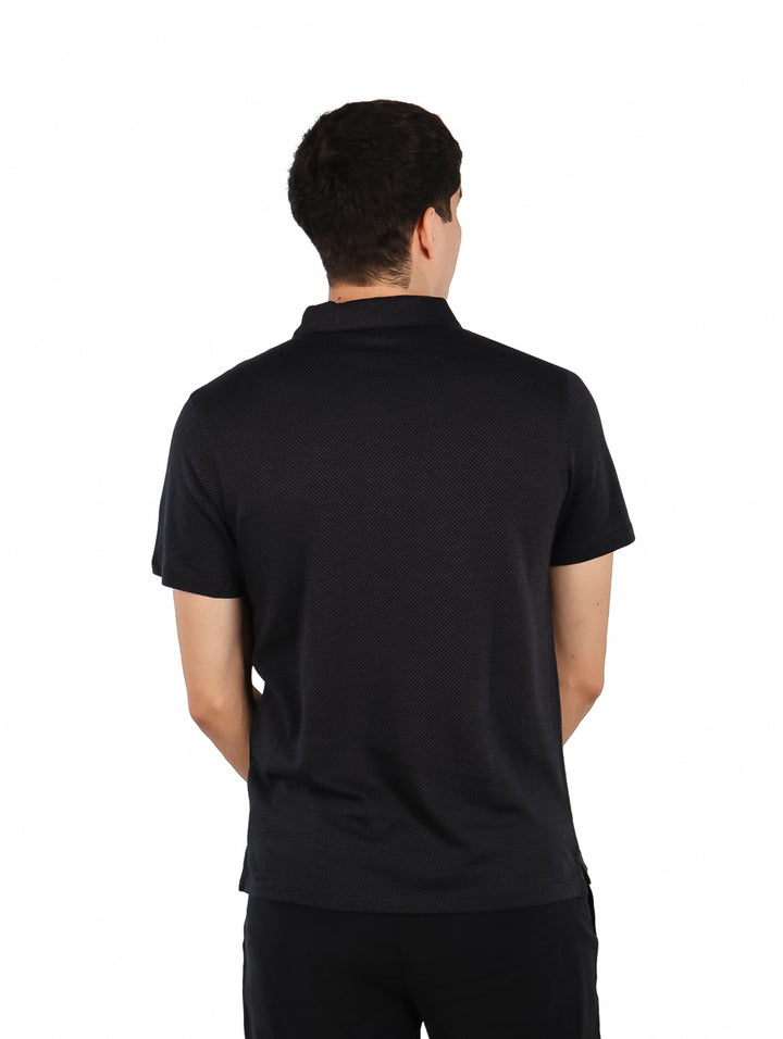 Hombre vistiendo una camiseta polo negra de manga corta.
