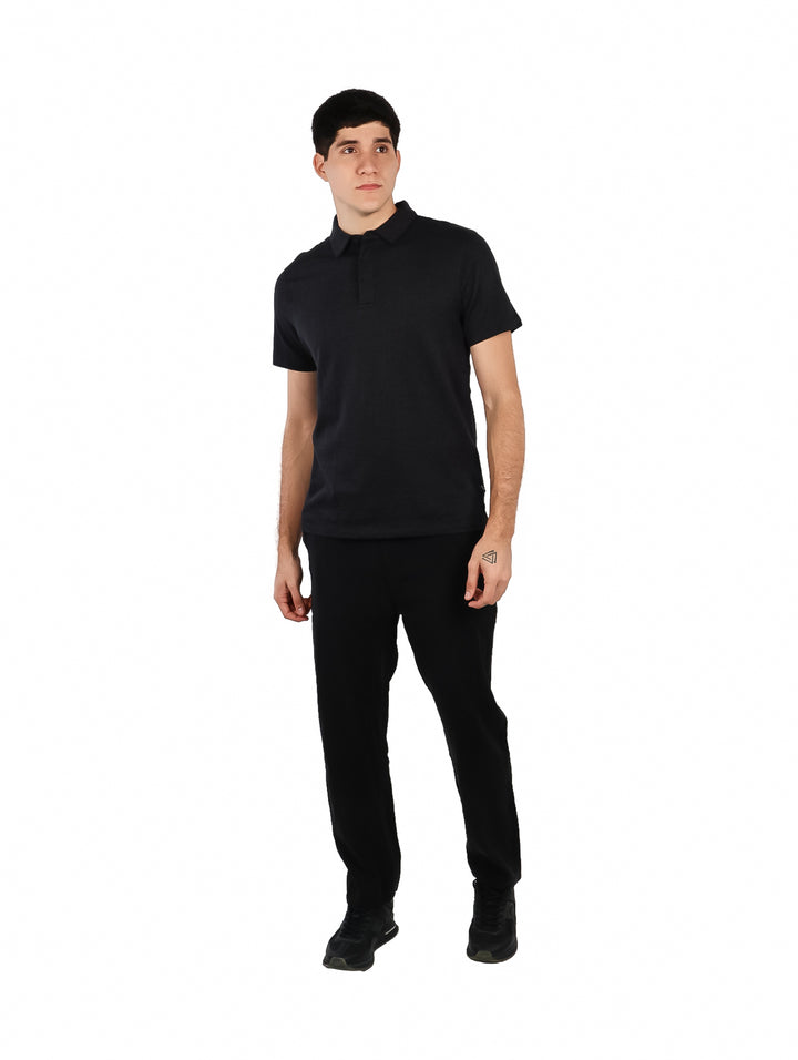 Hombre vistiendo una camiseta polo negra de manga corta.