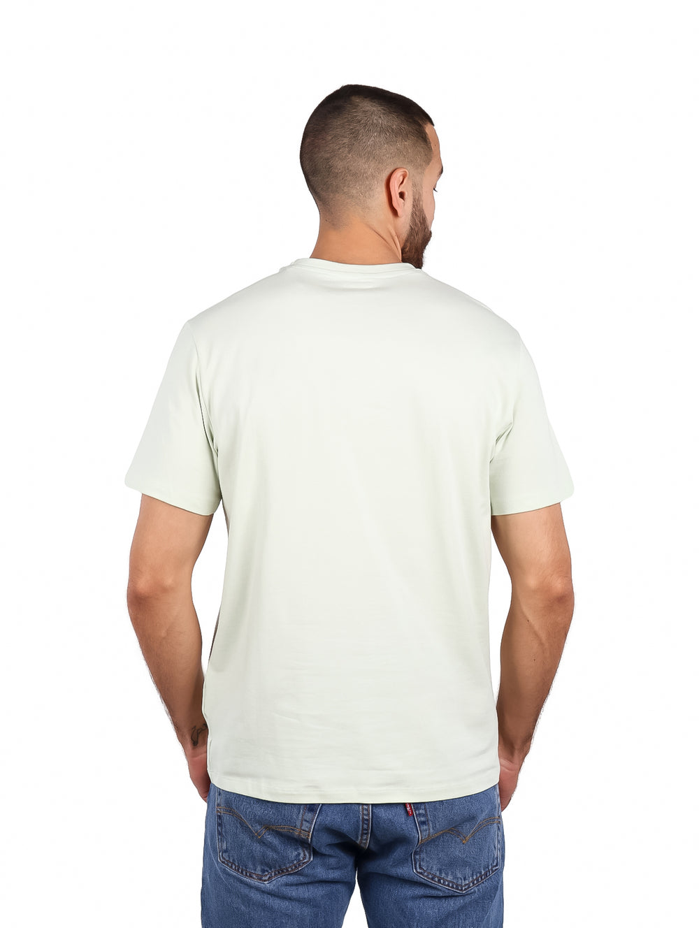 Hombre vistiendo camiseta de manga corta color menta pálido con logo DKNY en el pecho.
