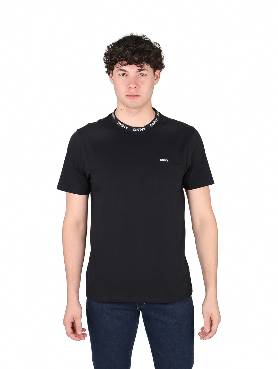 Hombre vistiendo camiseta negra de manga corta DKNY con logotipo blanco en el cuello y pecho.