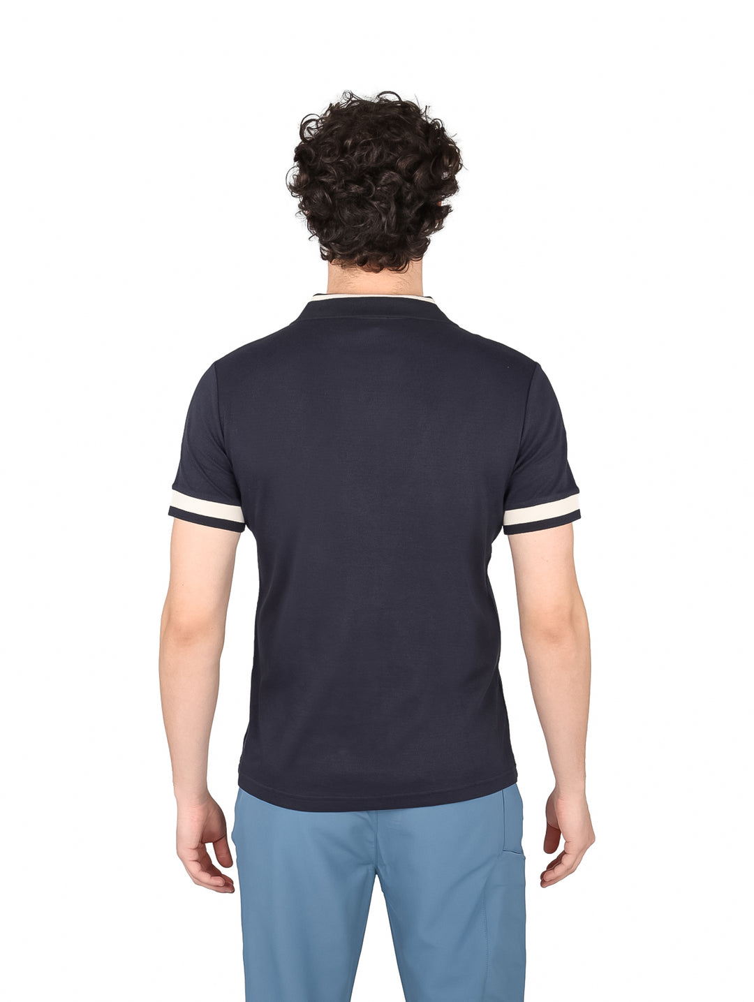 Hombre vistiendo una playera polo color azul marino con detalles en blanco en mangas y cuello.