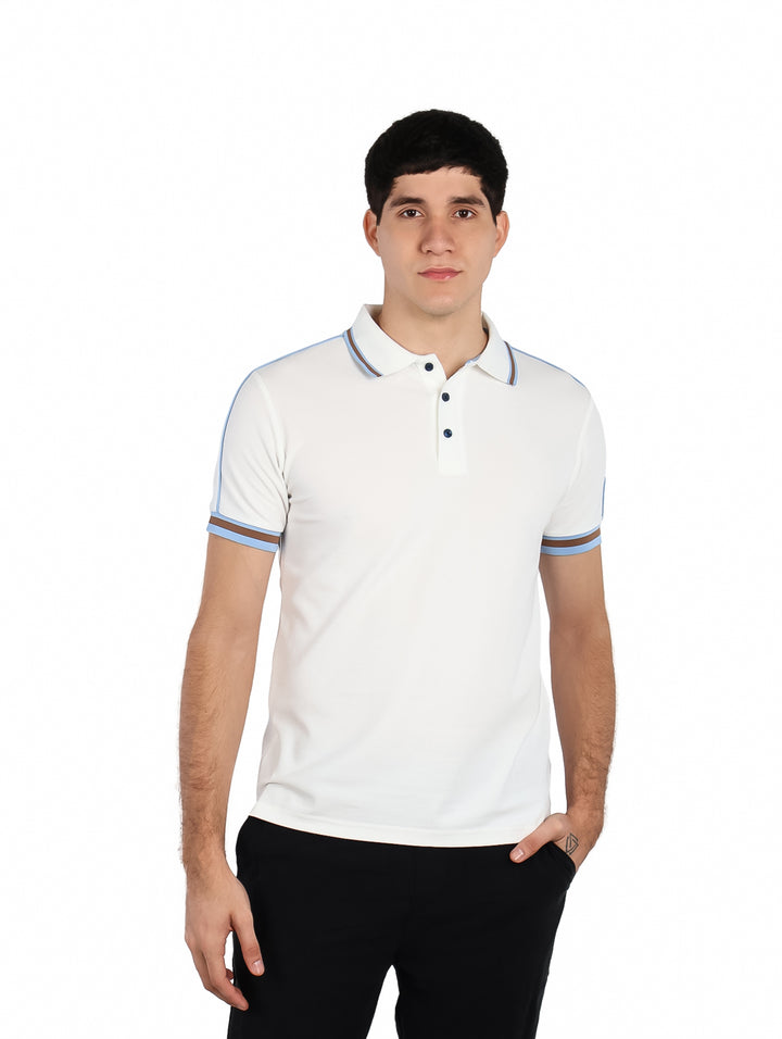 Hombre vistiendo playera polo blanca con detalles de rayas azules y cafés en cuello y mangas.