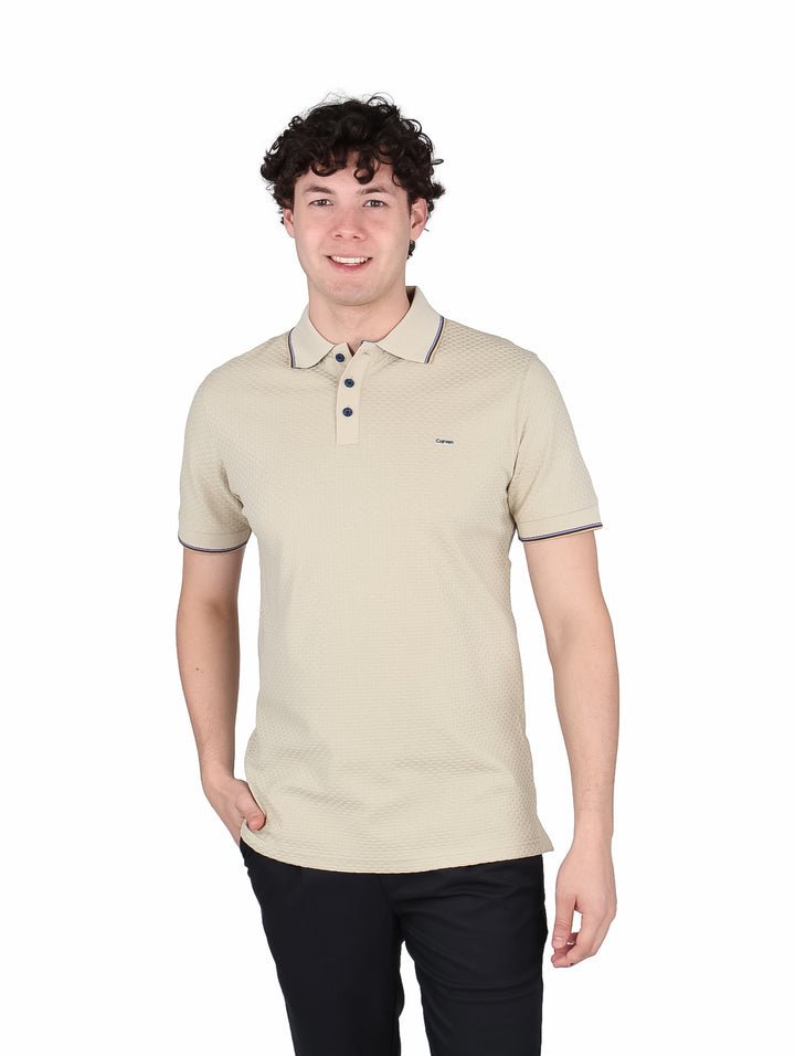 Hombre vistiendo playera polo color sand con textura y detalles en azul marino en cuello y mangas.