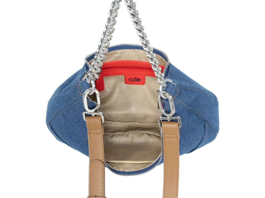 Bolsa de hombro Cloe en color azul tipo mezclilla con cadena plateada y correa marrón.