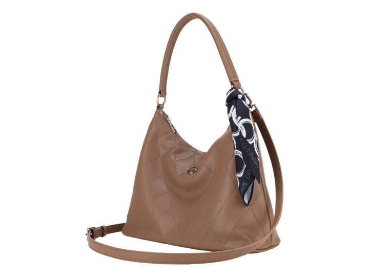 Bolsa de hombro color camel con diseño acolchado y un pañuelo decorativo azul y blanco en la asa.