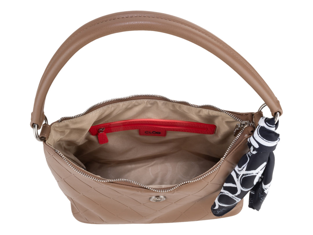 Bolsa de hombro color camel con diseño acolchado y un pañuelo decorativo azul y blanco en la asa.