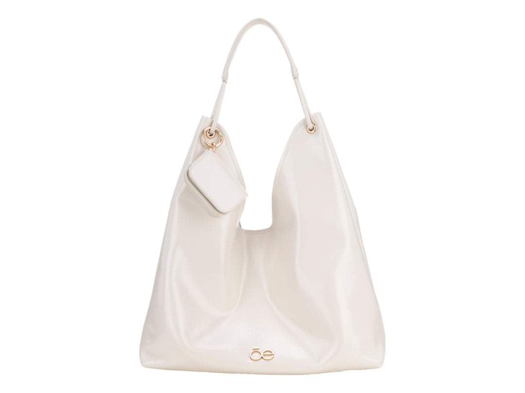 Bolsa de hombro Cloe en color beige con acabado brillante, diseño hobo y asa sencilla.