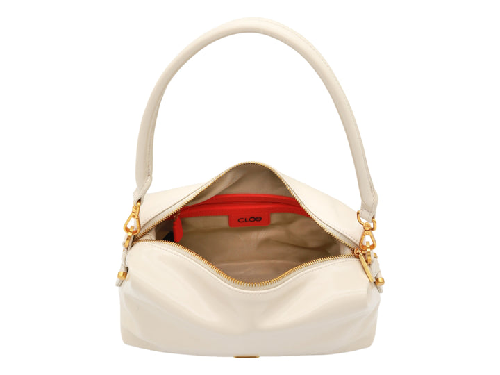 Bolso Cloe color beige con herrajes dorados, asa corta y correa larga ajustable.