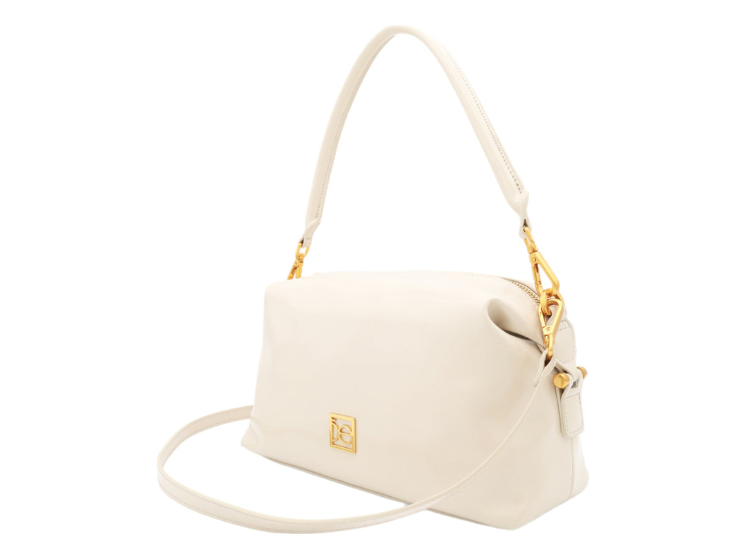 Bolso Cloe color beige con herrajes dorados, asa corta y correa larga ajustable.