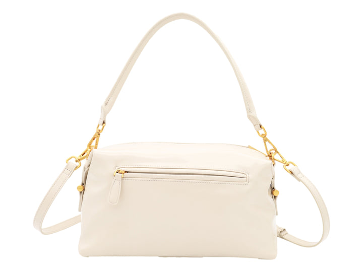 Bolso Cloe color beige con herrajes dorados, asa corta y correa larga ajustable.
