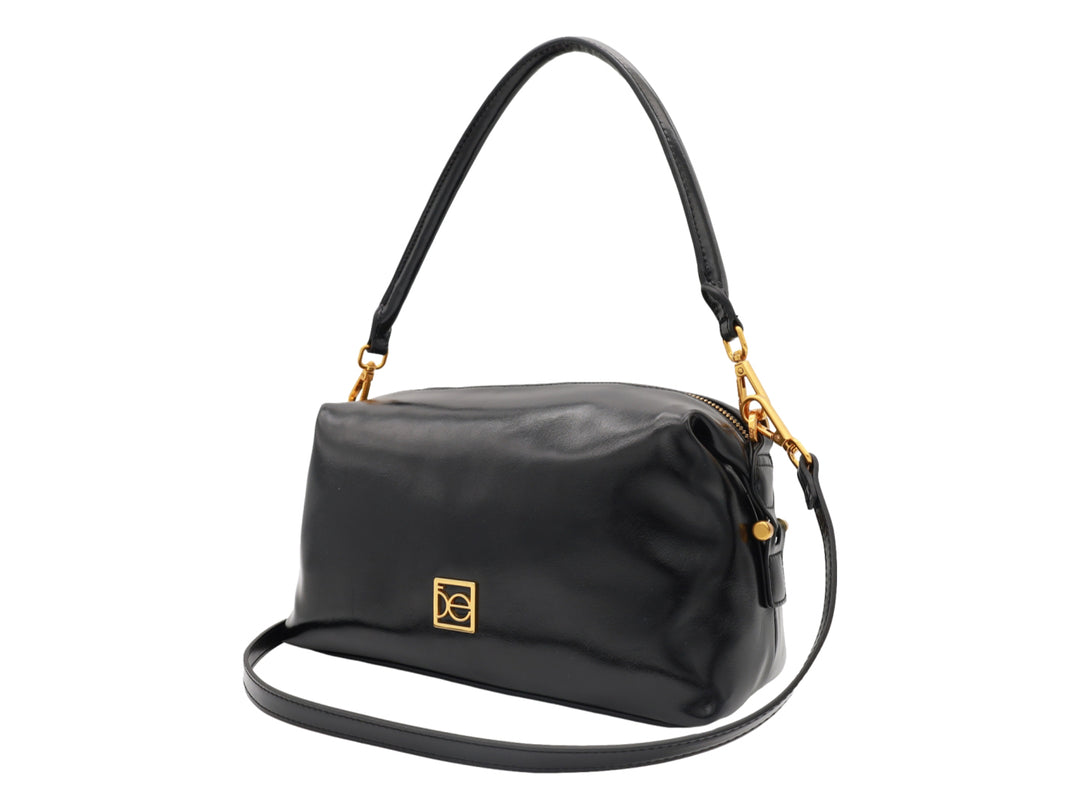 Bolso Cloe color negro con herrajes dorados, asa corta y correa larga ajustable.