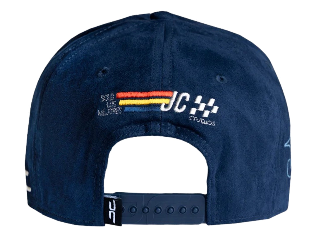 Gorra snapback color azul marino con logotipo bordado de JC HATS Studios en el frente y lateral.