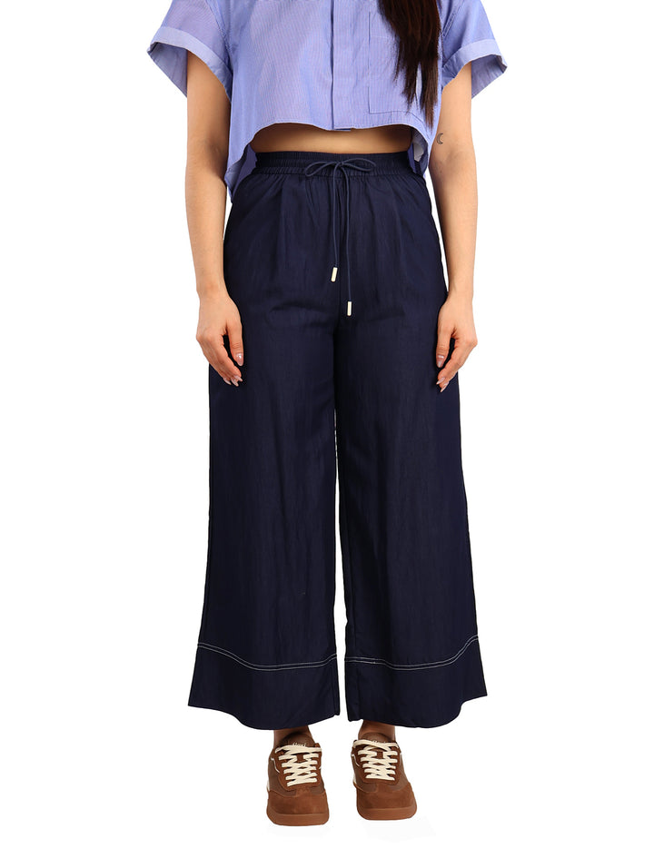 Pantalón azul marino de pierna ancha con cintura de jareta y detalle de costura blanca en el ruedo.