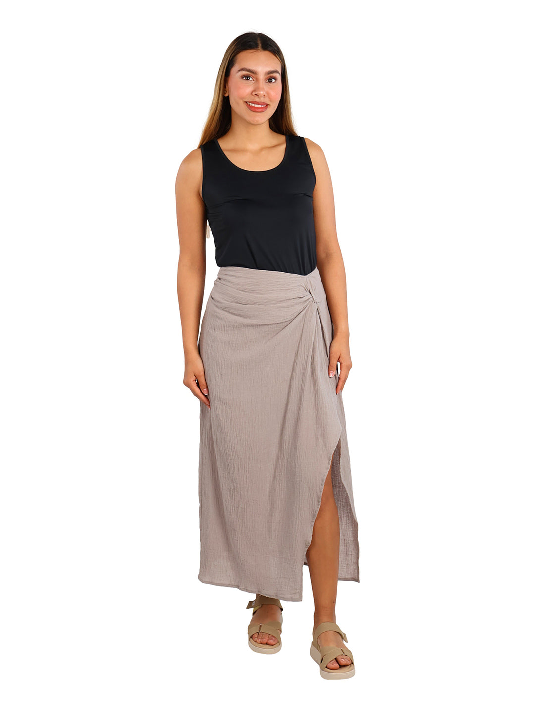 Mujer vistiendo una blusa negra sin mangas y una falda color beige.