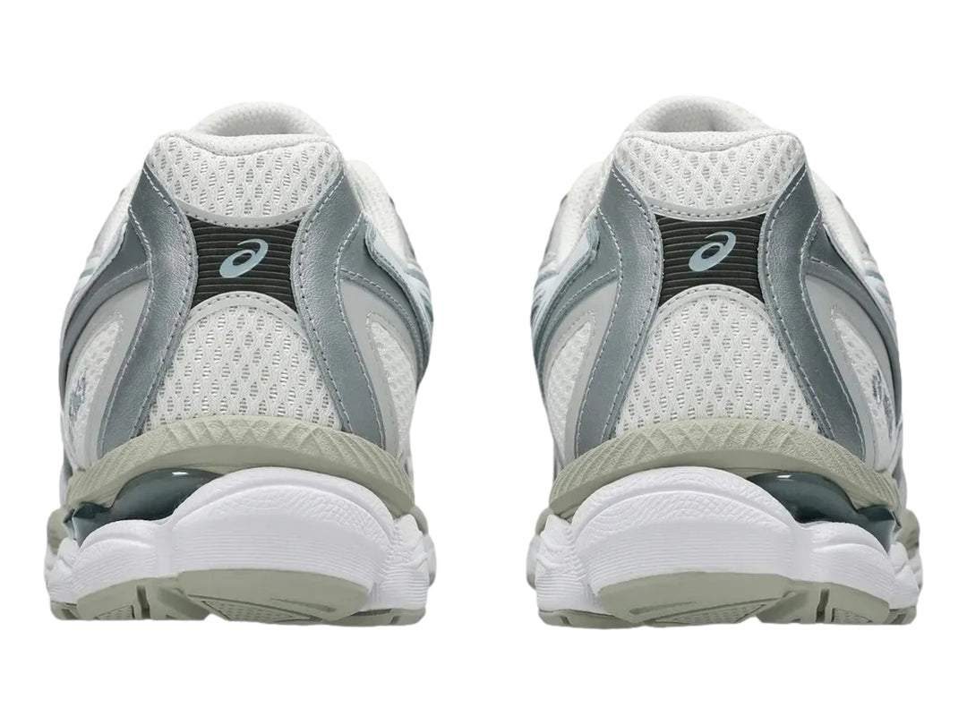 Tenis ASICS GEL-NYC en colores crema y gris delfín con diseño deportivo y suela amortiguada.