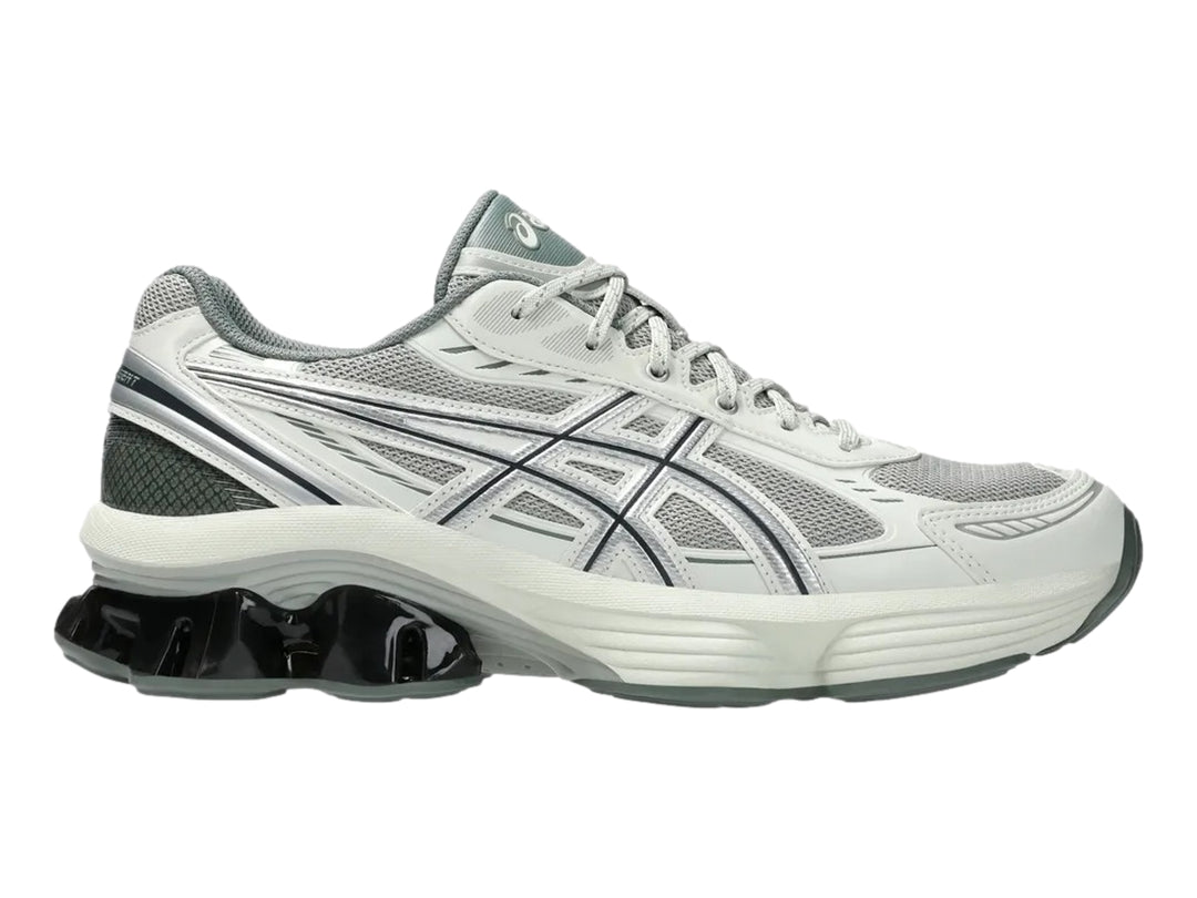 Tenis deportivos ASICS color gris y plata con suela blanca y detalle negro brillante en el talón.