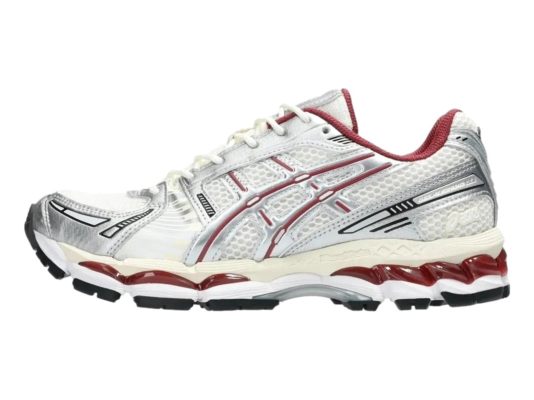 Tenis deportivos ASICS Gel-Kayano 12.1 en colores crema y plata con detalles en rojo y suela negra.