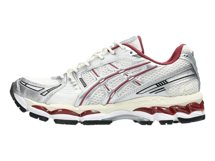 Tenis deportivos ASICS Gel-Kayano 12.1 en colores crema y plata con detalles en rojo y suela negra.