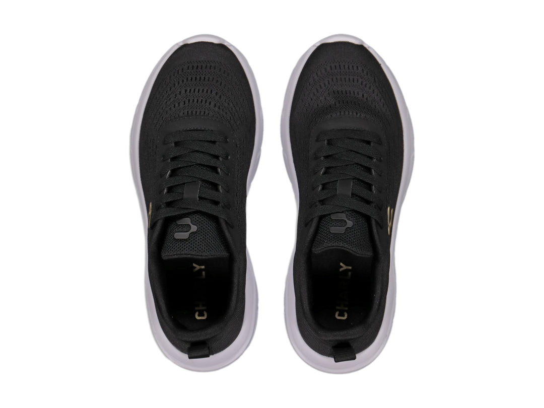 Tenis deportivos Charly color negro con suela blanca y logotipo dorado en el costado.