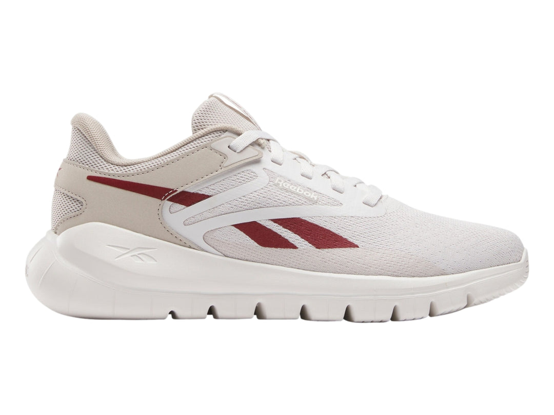 Tenis deportivos Reebok color gris claro con detalles rojos y suela blanca.