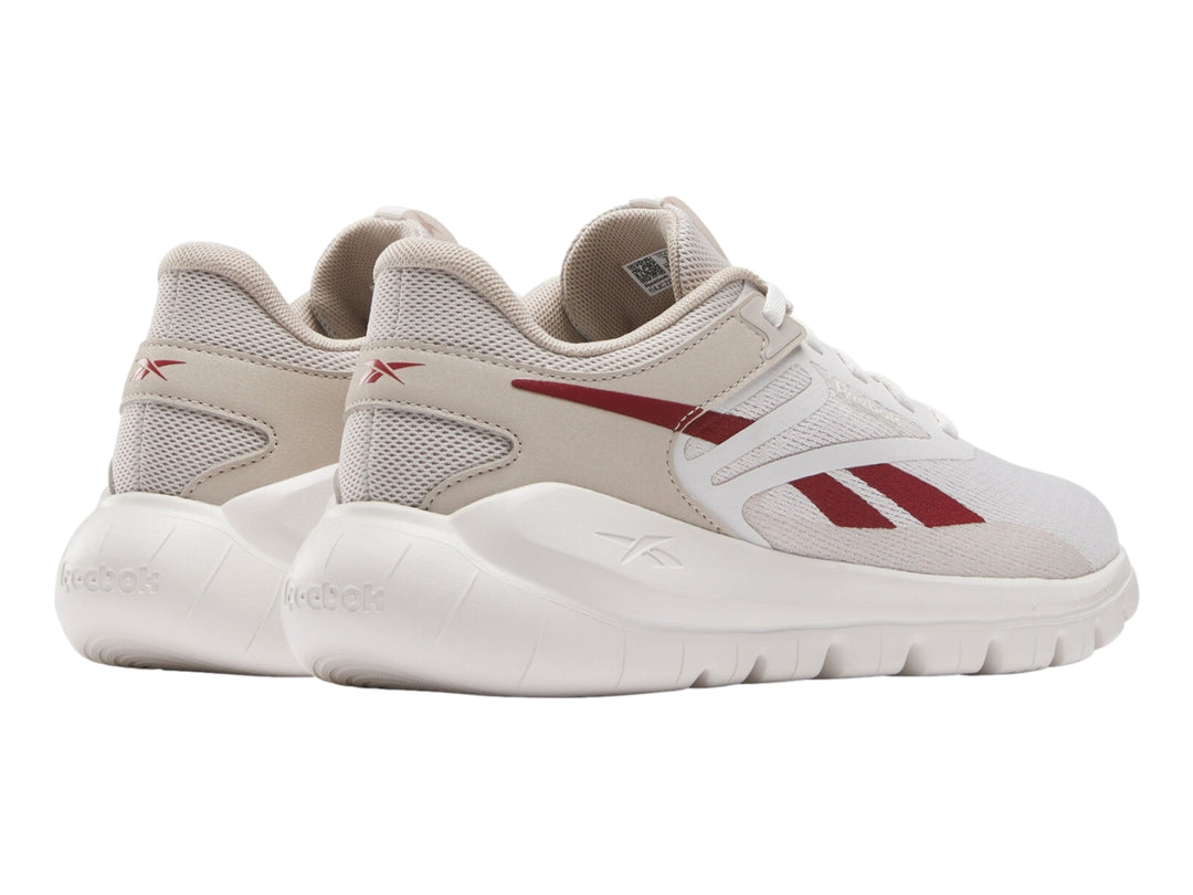 Tenis deportivos Reebok color gris claro con detalles rojos y suela blanca.