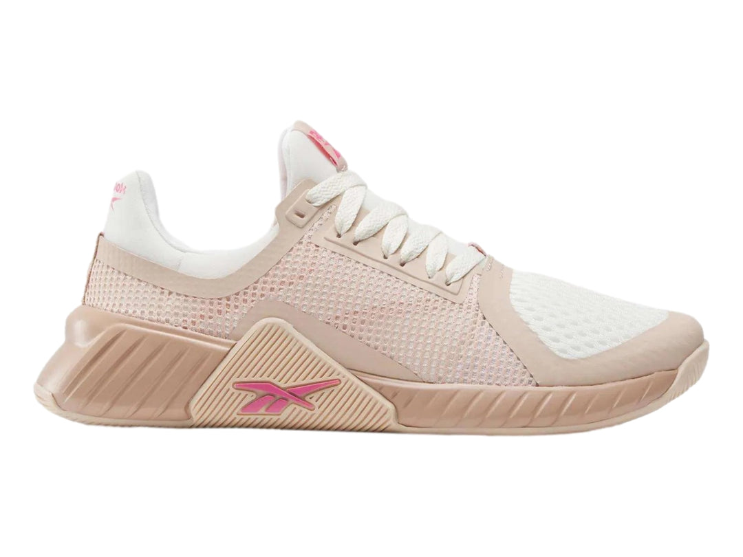 Tenis deportivos Reebok en color rosa palo y blanco con detalles en malla y suela robusta.
