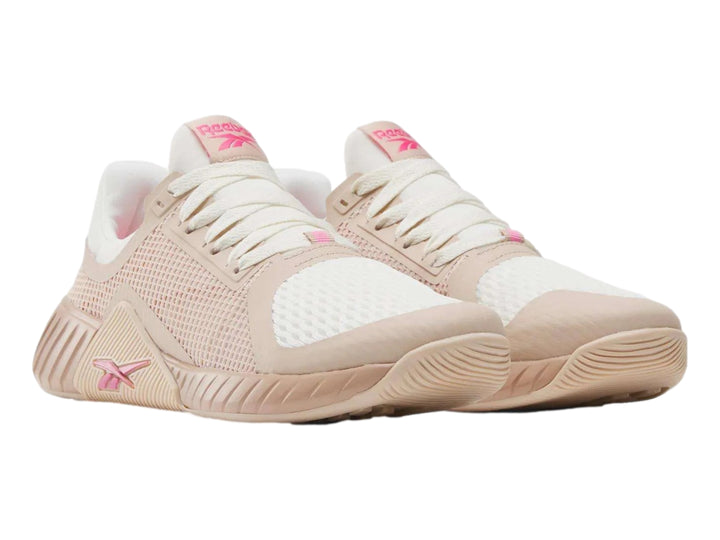 Tenis deportivos Reebok en color rosa palo y blanco con detalles en malla y suela robusta.