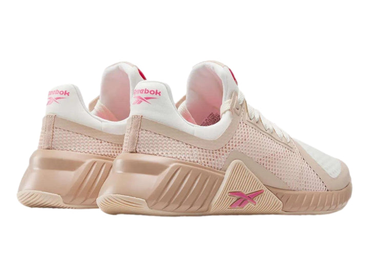 Tenis deportivos Reebok en color rosa palo y blanco con detalles en malla y suela robusta.
