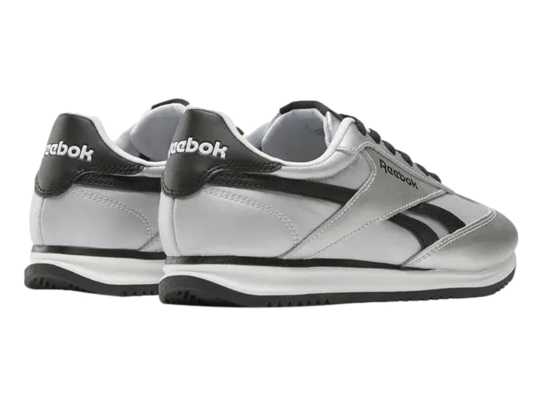 Tenis deportivos Reebok color plateado metálico con detalles y suela negra.
