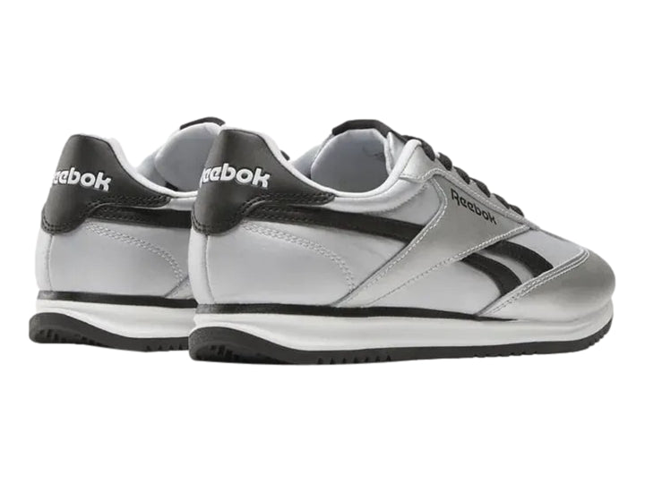 Tenis deportivos Reebok color plateado metálico con detalles y suela negra.