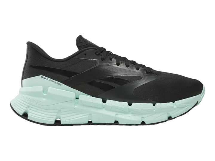 Tenis deportivos Reebok color negro con suela ancha en color verde menta.
