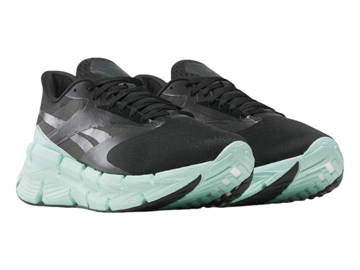 Tenis deportivos Reebok color negro con suela ancha en color verde menta.