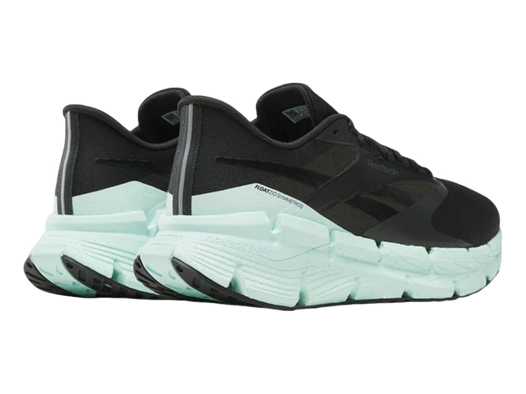 Tenis deportivos Reebok color negro con suela ancha en color verde menta.