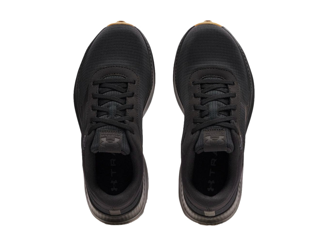 Tenis deportivos Under Armour color negro con suela de goma marrón.