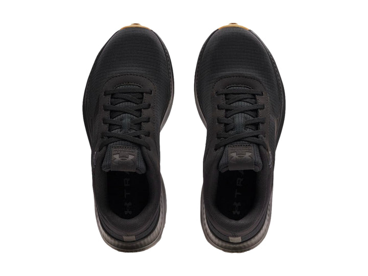 Tenis deportivos Under Armour color negro con suela de goma marrón.