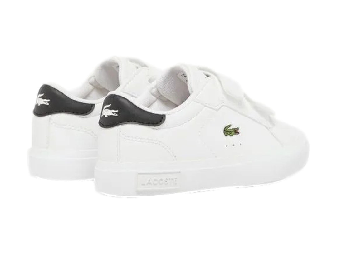 Tenis blancos Lacoste con cierre de velcro y detalle negro en el talón.