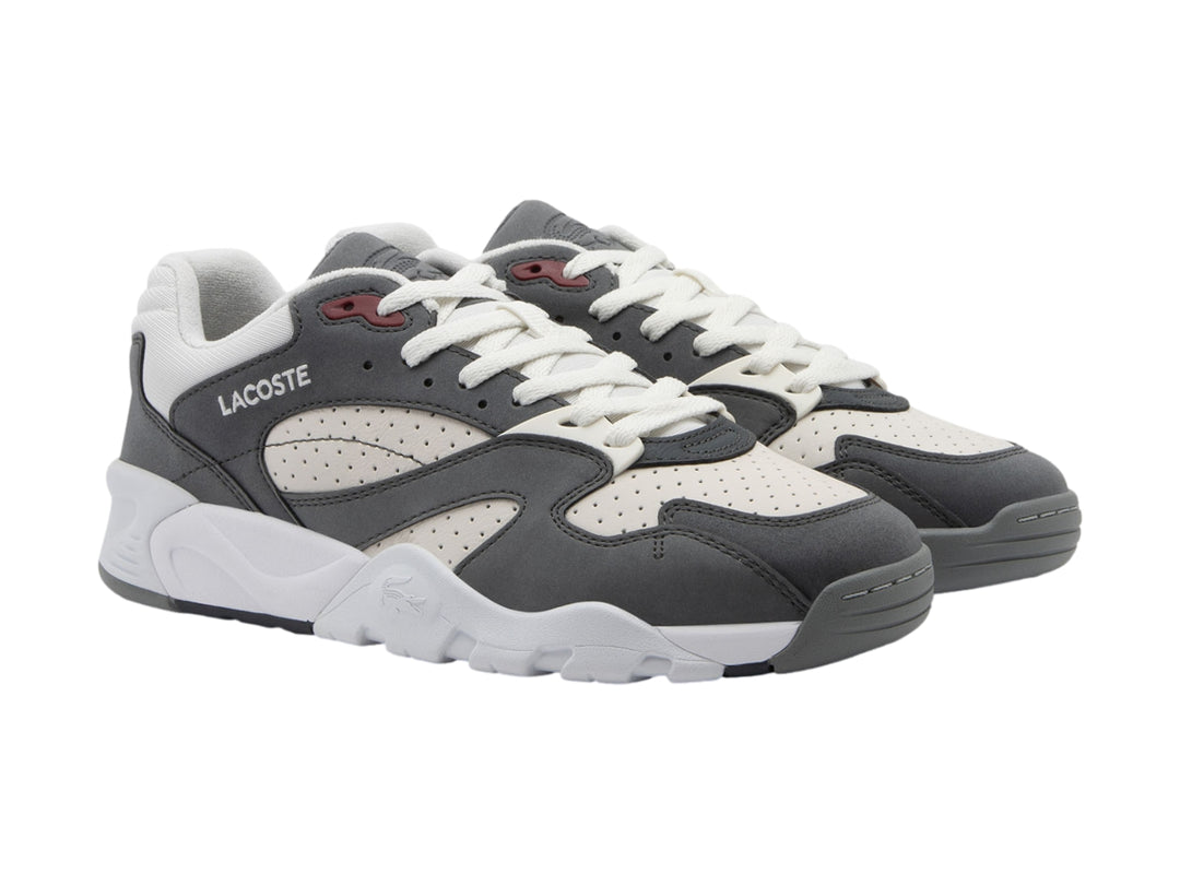 Tenis Lacoste Game Trainer en colores gris oscuro y blanco con suela robusta y detalles en rojo.