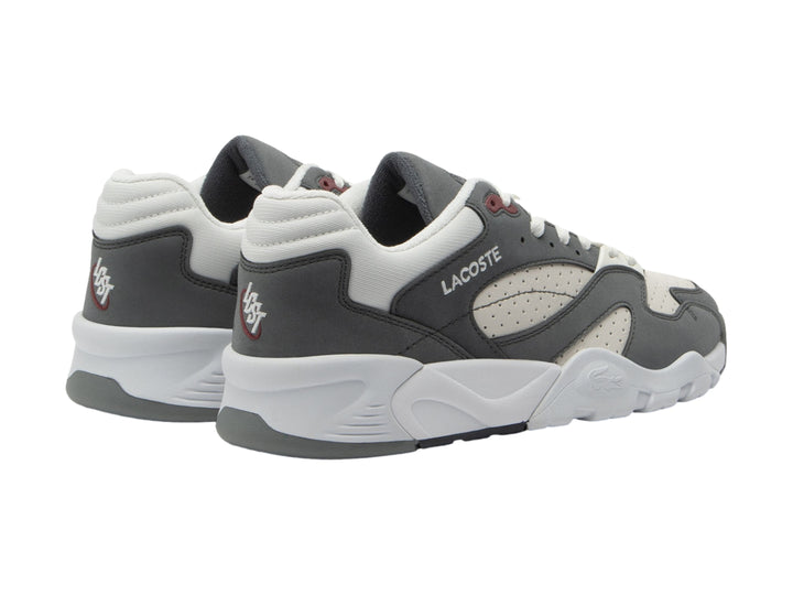 Tenis Lacoste Game Trainer en colores gris oscuro y blanco con suela robusta y detalles en rojo.