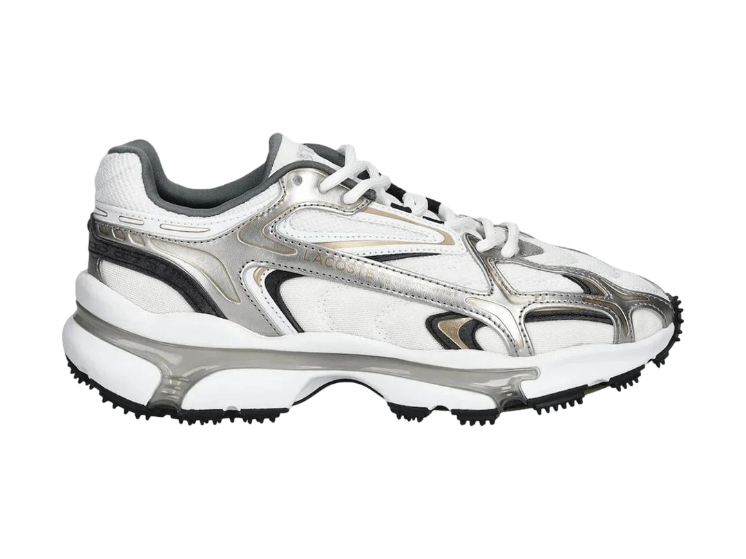 Tenis deportivos Lacoste color blanco y plateado con suela gruesa y diseño moderno.