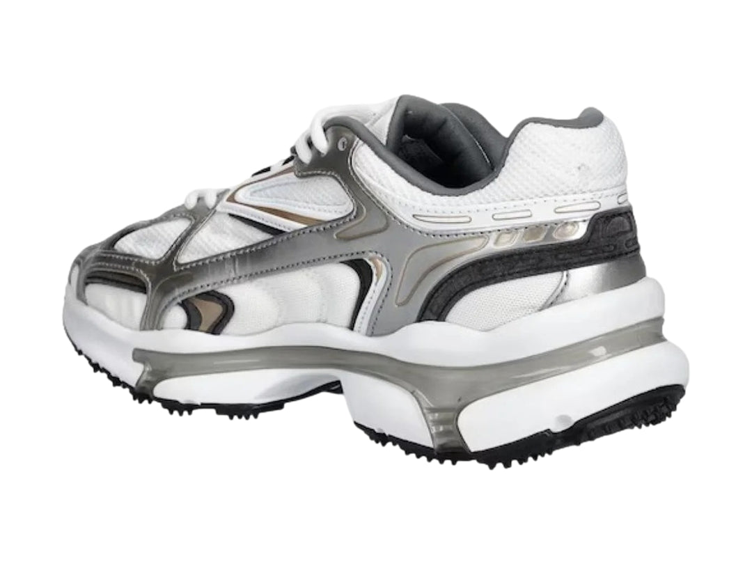 Tenis deportivos Lacoste color blanco y plateado con suela gruesa y diseño moderno.