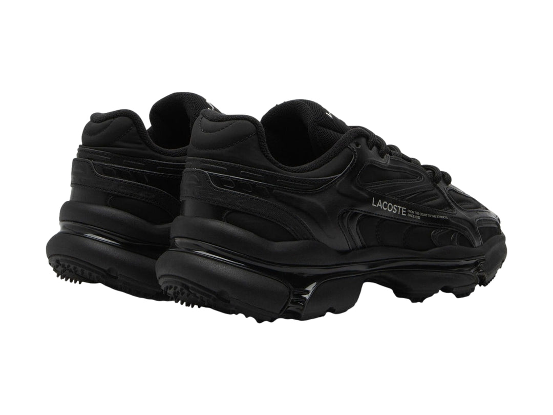 Tenis deportivos Lacoste color negro con suela gruesa y diseño moderno.