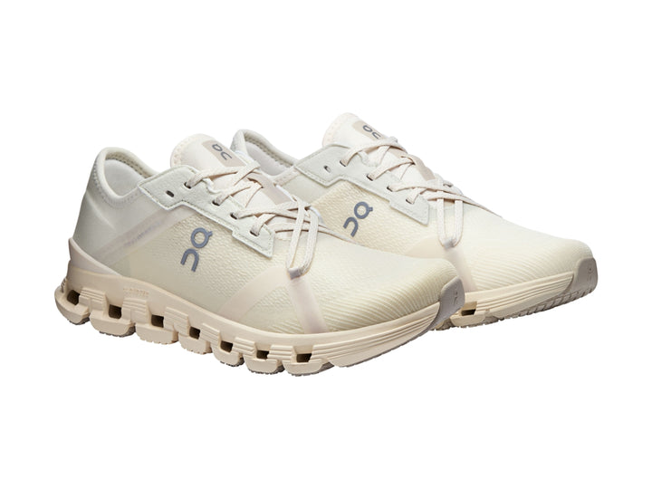 Tenis deportivos On Cloud color blanco hueso con suela amortiguada y diseño moderno.
