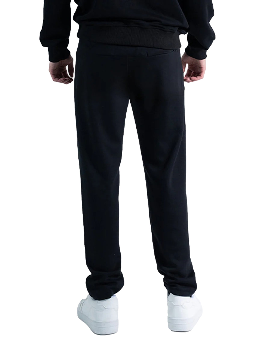 Hombre vistiendo un pantalón deportivo Everlast de color negro con calzado blanco sobre fondo blanco.