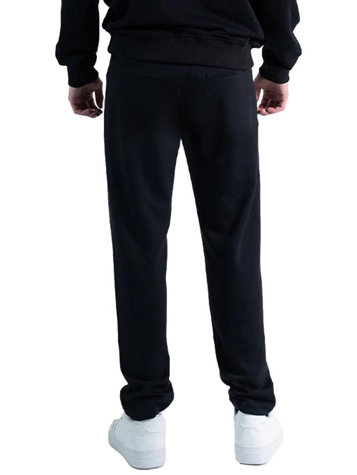 Hombre vistiendo un pantalón deportivo Everlast de color negro con calzado blanco sobre fondo blanco.